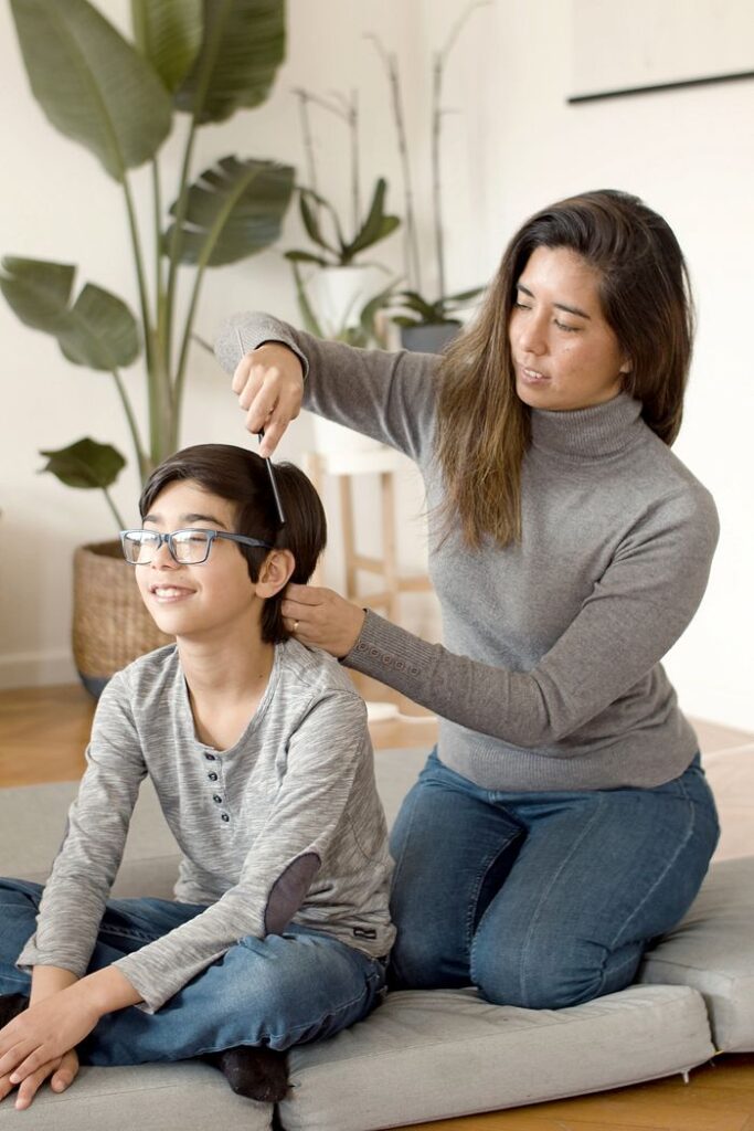 Mother and son bonding over a home haircut session in a cozy indoor setting.
